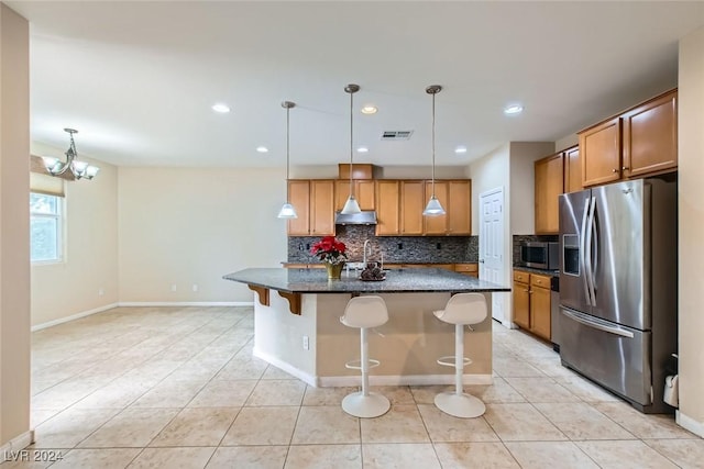 kitchen featuring a breakfast bar, backsplash, an inviting chandelier, appliances with stainless steel finishes, and a kitchen island