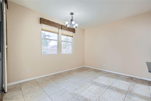 empty room featuring light tile patterned floors and an inviting chandelier