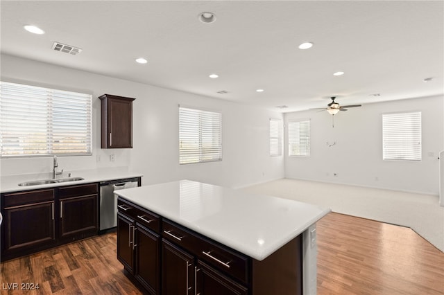 kitchen featuring stainless steel dishwasher, a wealth of natural light, a kitchen island, and sink