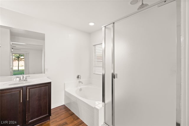 bathroom with vanity, wood-type flooring, and shower with separate bathtub