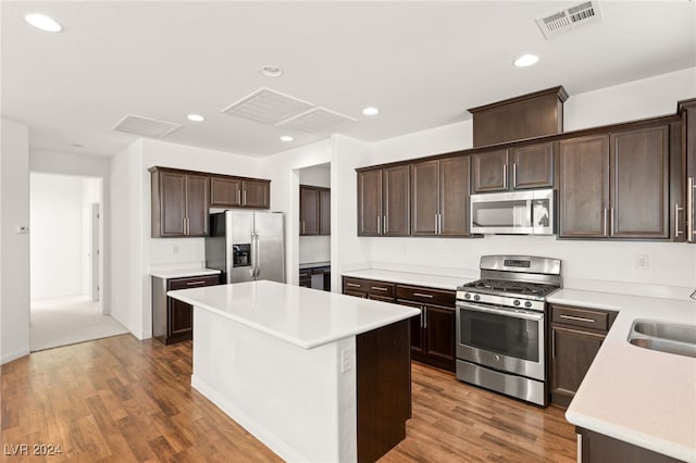 kitchen featuring sink, a kitchen island, dark hardwood / wood-style floors, and appliances with stainless steel finishes