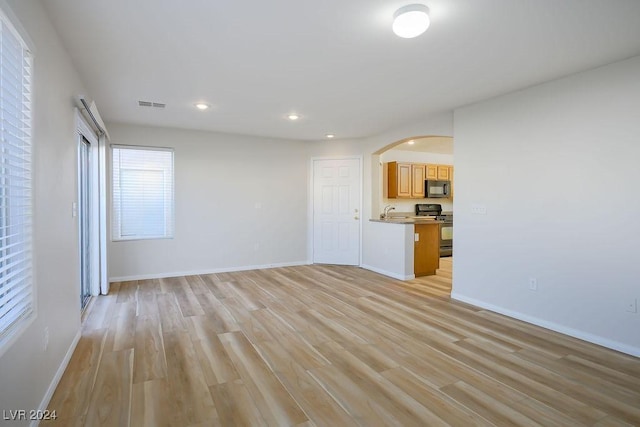 unfurnished living room with light hardwood / wood-style floors and sink