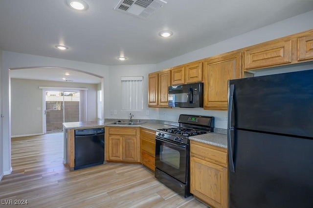 kitchen featuring kitchen peninsula, sink, light hardwood / wood-style floors, and black appliances