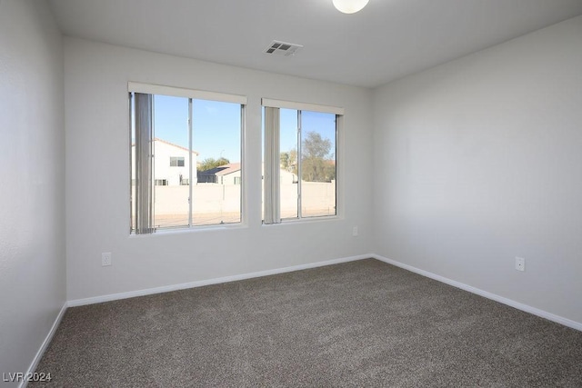 unfurnished room with dark colored carpet