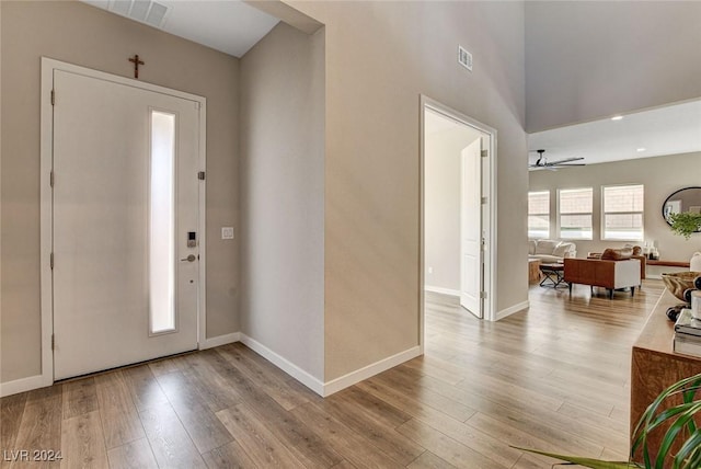 foyer entrance with ceiling fan and light hardwood / wood-style floors