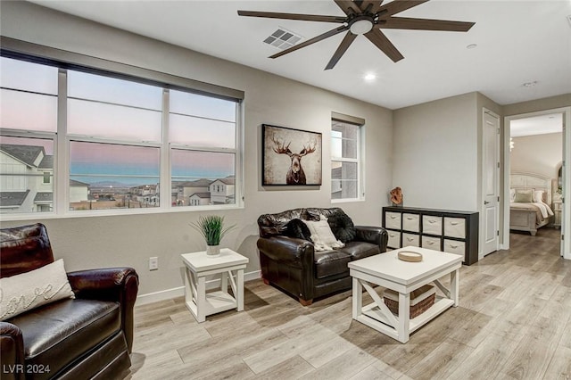 living room with light hardwood / wood-style flooring and ceiling fan