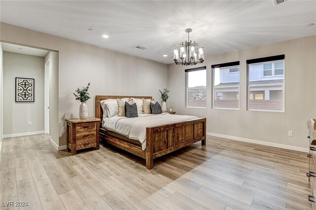 bedroom with light hardwood / wood-style floors and a chandelier