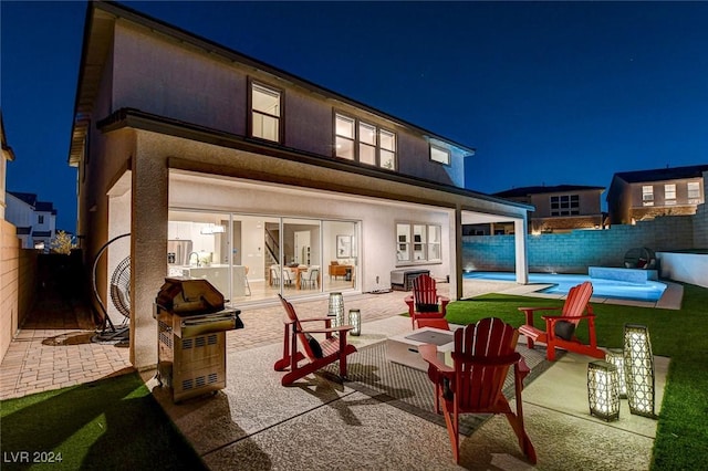 back house at twilight featuring a patio