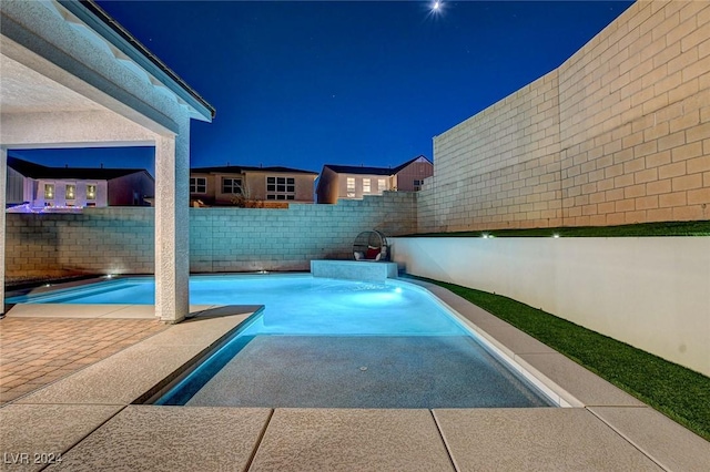 view of pool at twilight