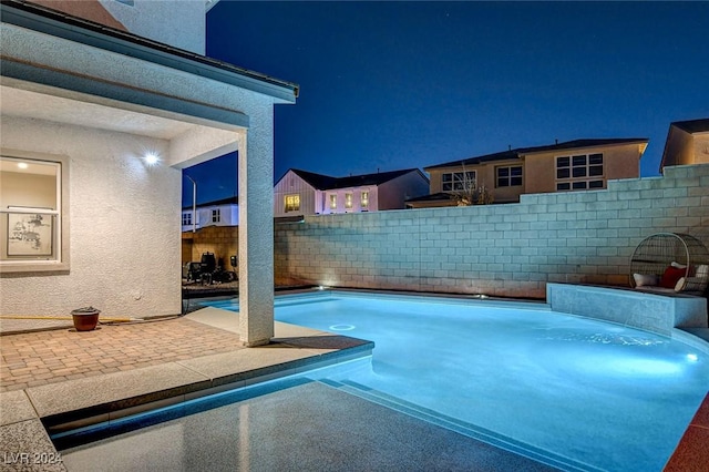 view of pool at twilight