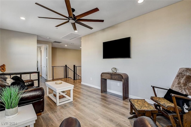 living room with ceiling fan and light hardwood / wood-style floors