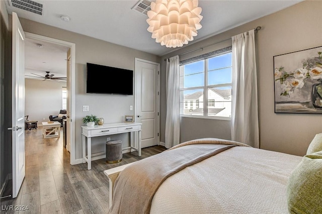 bedroom featuring a chandelier and hardwood / wood-style flooring