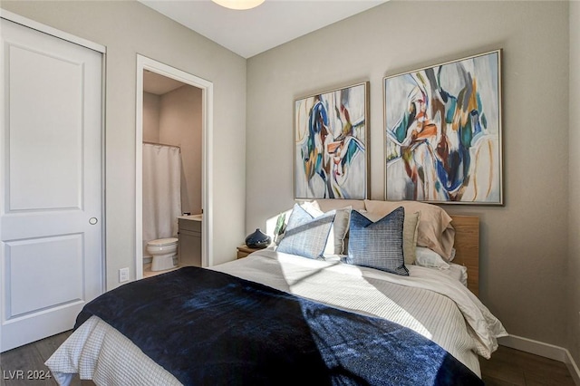 bedroom featuring dark hardwood / wood-style floors and ensuite bath