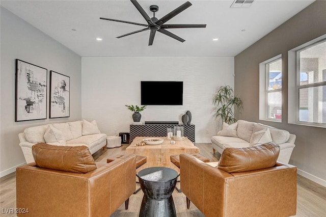 living room featuring light hardwood / wood-style floors and ceiling fan