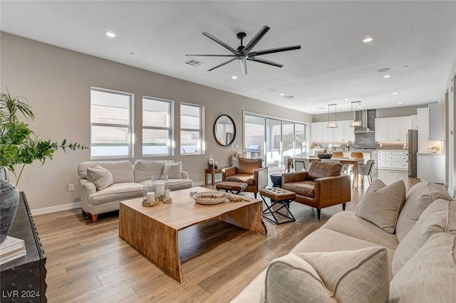 living room with light hardwood / wood-style flooring and ceiling fan