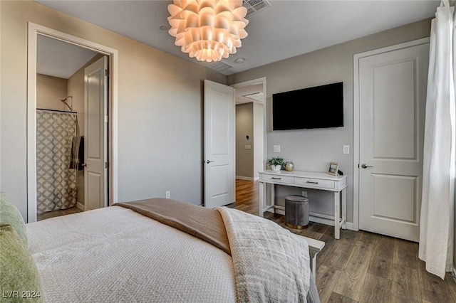 bedroom with dark hardwood / wood-style flooring and a notable chandelier