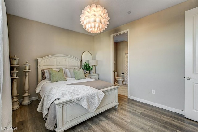 bedroom featuring a chandelier, hardwood / wood-style flooring, and ensuite bath