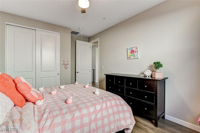 bedroom with ceiling fan, wood-type flooring, and a closet