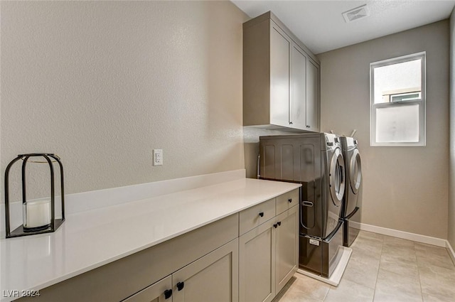 washroom featuring cabinets, independent washer and dryer, and light tile patterned flooring