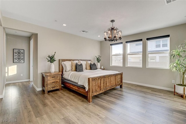 bedroom featuring light hardwood / wood-style floors and an inviting chandelier