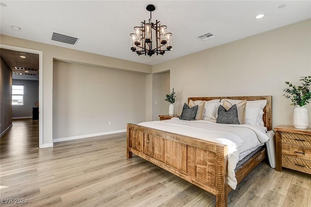 bedroom with hardwood / wood-style flooring and an inviting chandelier