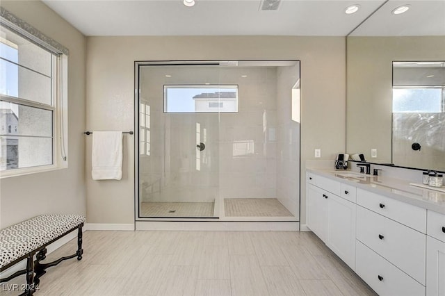 bathroom with vanity, a healthy amount of sunlight, and a tile shower