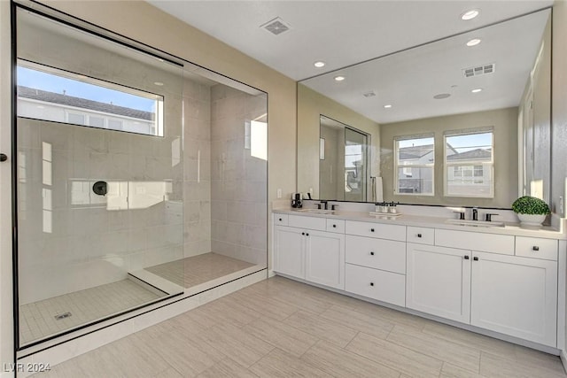 bathroom featuring vanity, a tile shower, and a wealth of natural light