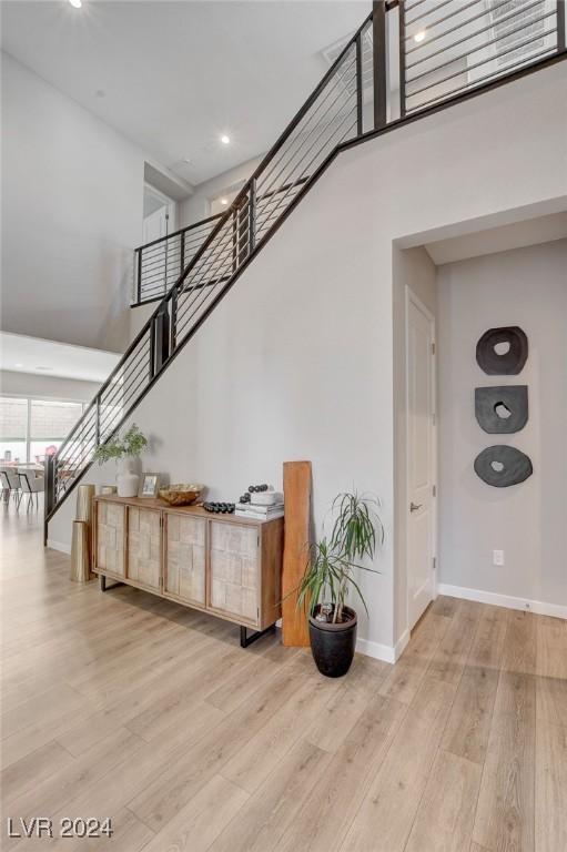 staircase with hardwood / wood-style floors and a towering ceiling