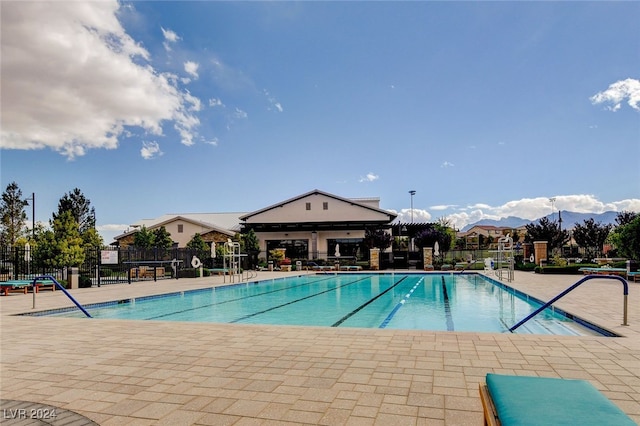 view of swimming pool featuring a mountain view and a patio