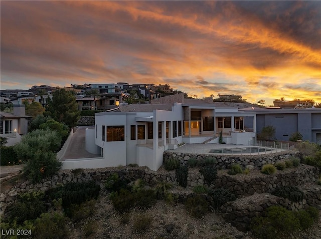 back house at dusk with a patio area