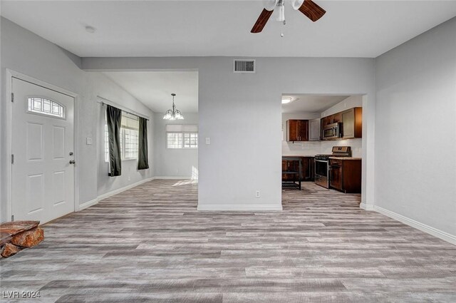 foyer featuring lofted ceiling, light hardwood / wood-style floors, and ceiling fan with notable chandelier