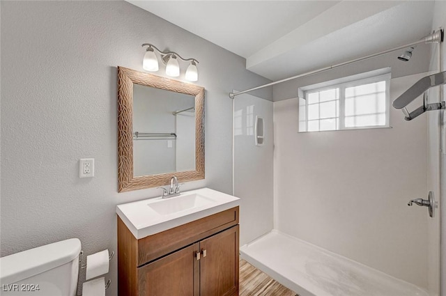 bathroom featuring walk in shower, vanity, and toilet