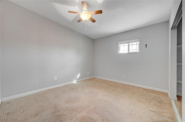 carpeted spare room with ceiling fan