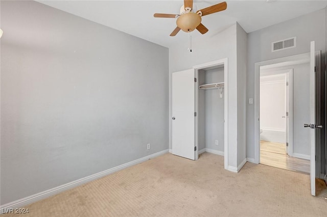 unfurnished bedroom featuring light carpet, a closet, and ceiling fan