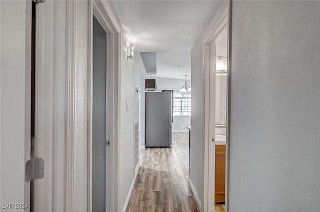 hall featuring a chandelier and light hardwood / wood-style floors