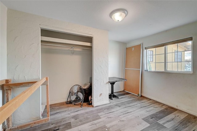 unfurnished bedroom with light hardwood / wood-style flooring and a closet