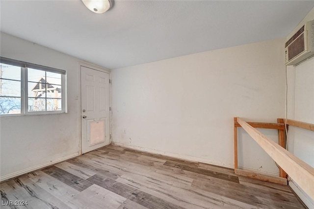 interior space with light hardwood / wood-style floors and an AC wall unit