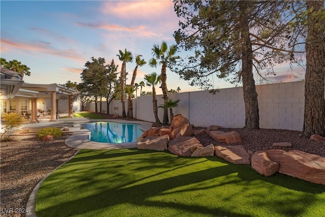 pool at dusk with a lawn