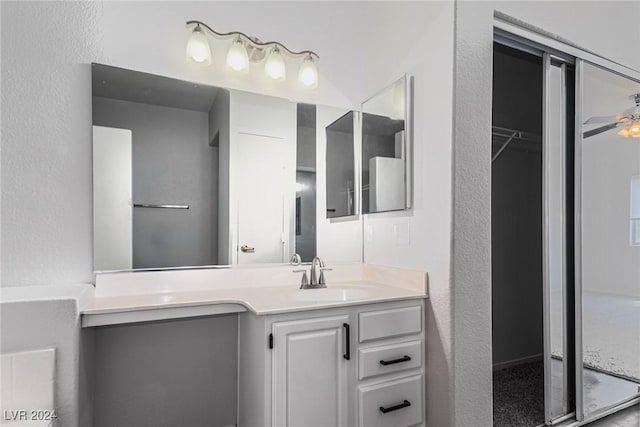 bathroom with vanity, ceiling fan, and vaulted ceiling