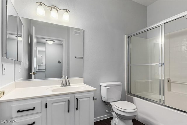 full bathroom featuring shower / bath combination with glass door, vanity, and toilet