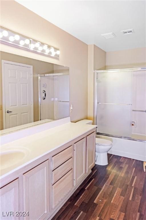 full bathroom featuring enclosed tub / shower combo, toilet, wood-type flooring, and vanity