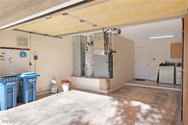 garage featuring washing machine and clothes dryer, heating unit, a garage door opener, and water heater