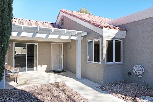 doorway to property with a pergola and a patio