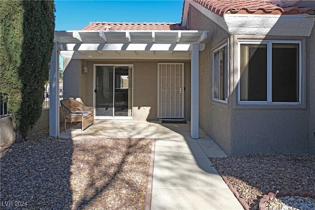 doorway to property featuring stucco siding, a pergola, and a tile roof