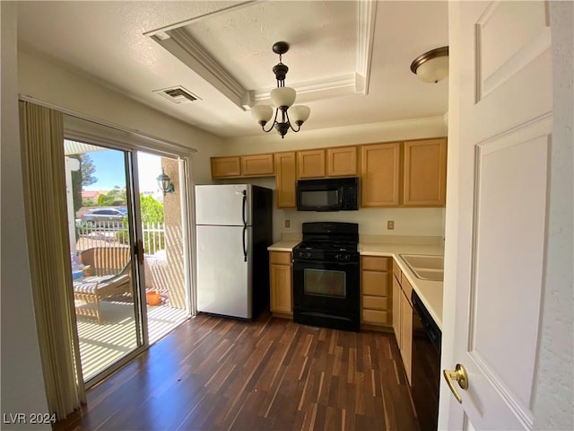 kitchen with dark wood-type flooring, a tray ceiling, black appliances, visible vents, and light countertops