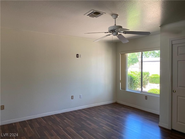unfurnished room featuring dark wood finished floors, baseboards, visible vents, a ceiling fan, and a textured ceiling