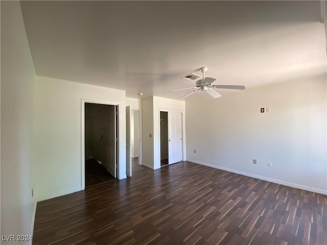 unfurnished room with dark wood-type flooring, visible vents, ceiling fan, and baseboards