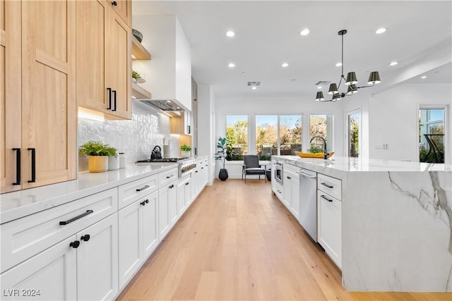 kitchen featuring light hardwood / wood-style floors, a healthy amount of sunlight, white cabinetry, and hanging light fixtures