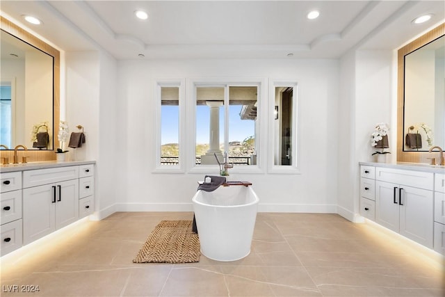 bathroom with a bathing tub, tile patterned flooring, and vanity