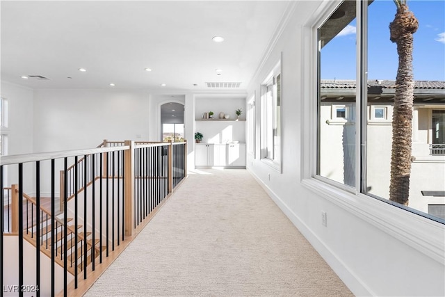 hall with light carpet and crown molding